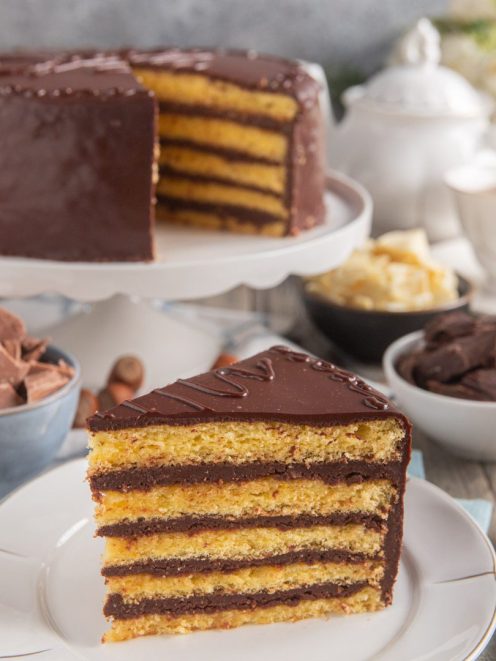 Torta Savoia a strati con pan di Spagna e crema al cioccolato, glassata e servita a fetta
