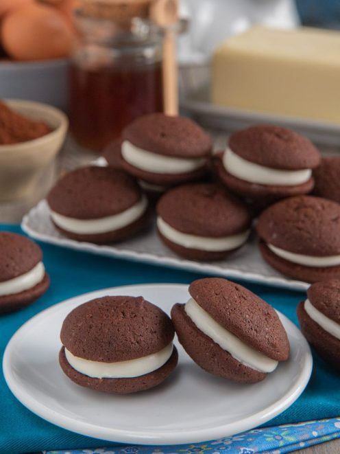 Whoopie pie al cioccolato farciti con crema bianca soffice, serviti in più porzioni