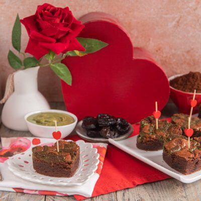 Brownies al fondente con prugne e pistacchio decorati con stecchini a cuore per San Valentino