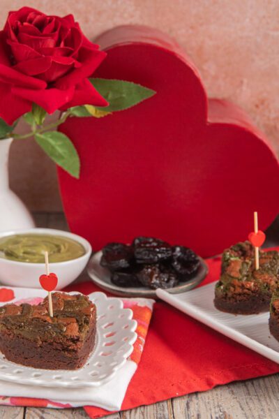 Brownies al fondente con prugne e pistacchio decorati con stecchini a cuore per San Valentino