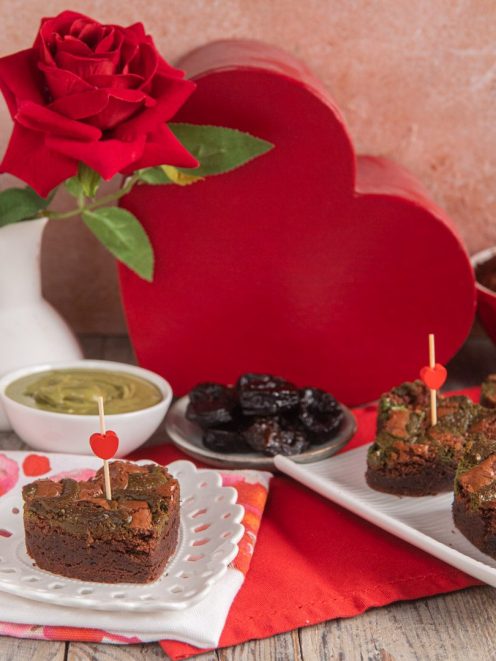 Brownies al fondente con prugne e pistacchio decorati con stecchini a cuore per San Valentino