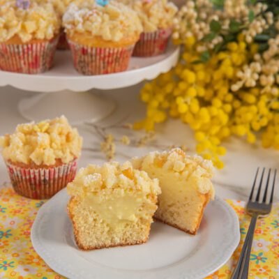 Muffin mimosa tagliato a metà con ripieno di crema al limone e copertura di briciole sbriciolate