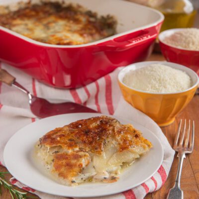 Parmigiana di patate e scamorza con crosta gratinata dorata, servita a fetta nel piatto