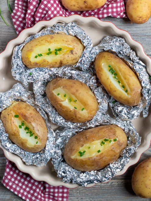 Patate al cartoccio aperte con burro fuso e erba cipollina tritata