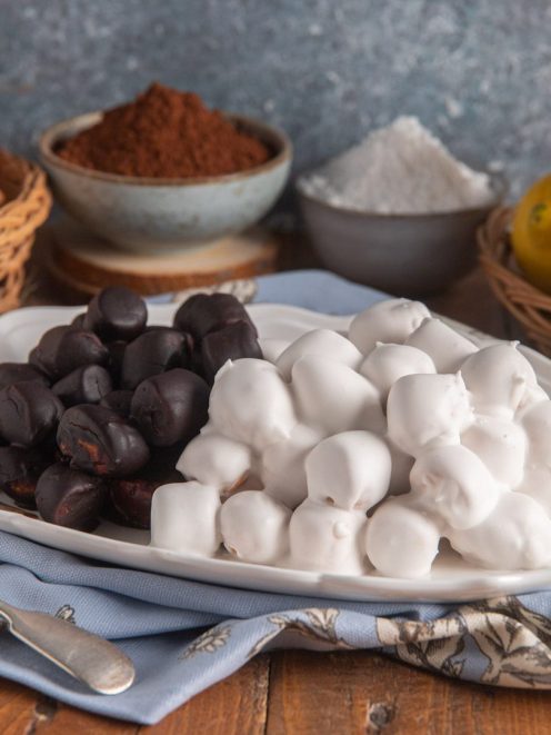 Pignolata glassata con glassa bianca al limone e glassa scura al cioccolato, servita su vassoio