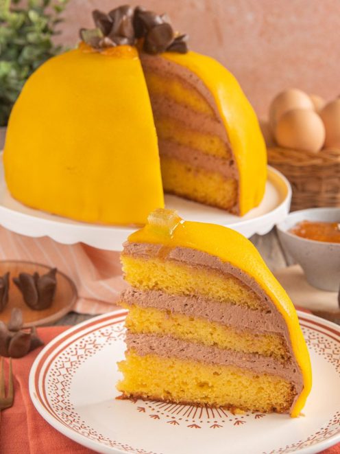 Polenta e osei a fetta con pan di spagna, crema al cioccolato e glassa gialla a forma di cupola