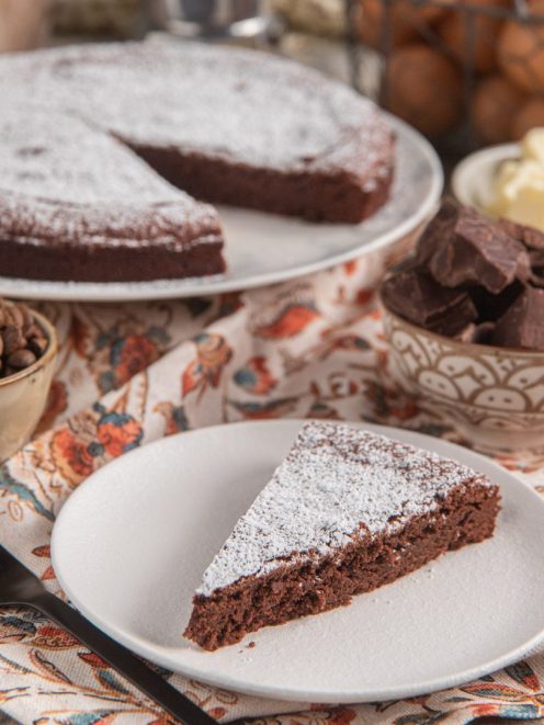 Torta tenerina al caffè con una fetta servita, spolverata di zucchero a velo