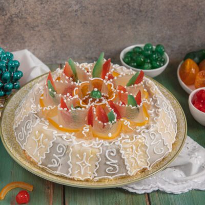 Cassata siciliana decorata con glassa reale, frutta candita colorata e zuccherini bianchi