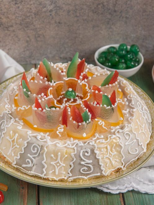 Cassata siciliana decorata con glassa reale, frutta candita colorata e zuccherini bianchi