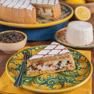 Cassata siciliana al forno in una fetta con ripieno di ricotta e gocce di cioccolato, spolverata di zucchero a velo