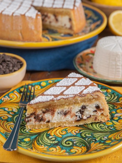 Cassata siciliana al forno in una fetta con ripieno di ricotta e gocce di cioccolato, spolverata di zucchero a velo