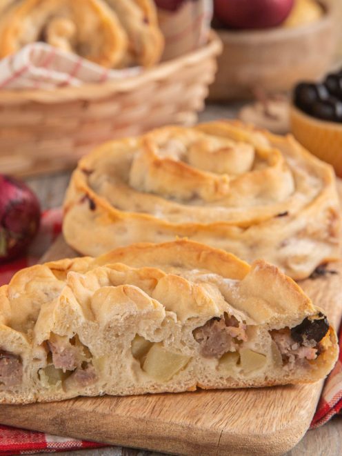 Mbriulate siciliane tagliate a metà con ripieno di carne, patate e olive nere