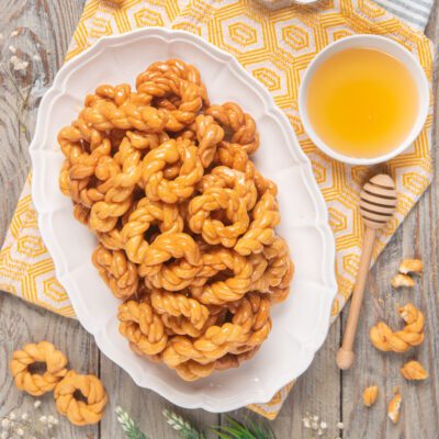 Origliette di Ozieri fritte e glassate al miele, servite in abbondanza su vassoio