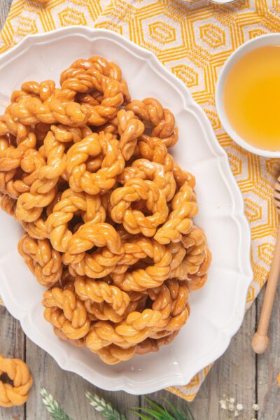 Origliette di Ozieri fritte e glassate al miele, servite in abbondanza su vassoio