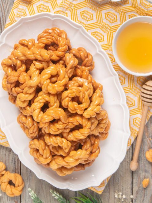 Origliette di Ozieri fritte e glassate al miele, servite in abbondanza su vassoio