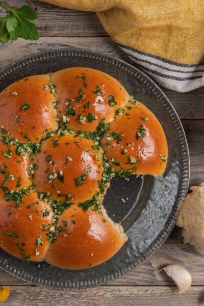 Pampushky dorati conditi con aglio tritato e prezzemolo, con un panino staccato a lato