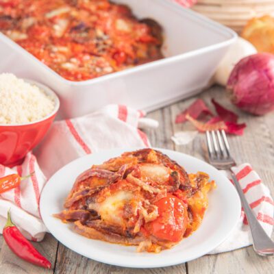 Parmigiana di cipolle di Cannara con pomodorini e mozzarella filante, servita in porzione