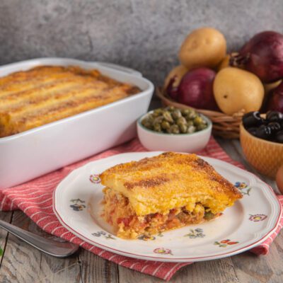 Pitta di patate con crosta dorata e croccante, ripiena di pomodoro, olive e capperi