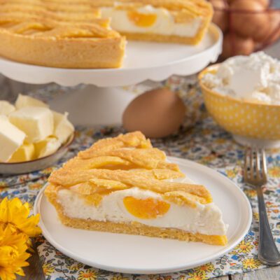 Fetta di scarcedda con uova sode intere nel ripieno di ricotta e crosta intrecciata dorata