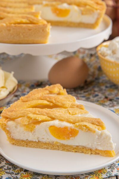 Fetta di scarcedda con uova sode intere nel ripieno di ricotta e crosta intrecciata dorata