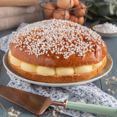Tarte tropézienne farcita con crema pasticcera a ciuffi e granella di zucchero in superficie