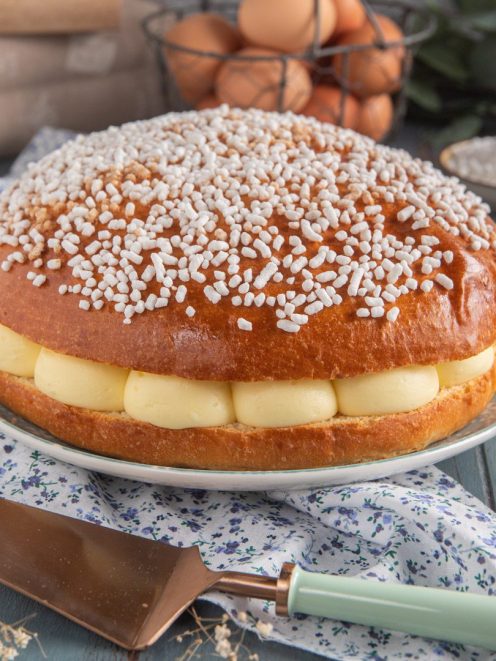 Tarte tropézienne farcita con crema pasticcera a ciuffi e granella di zucchero in superficie
