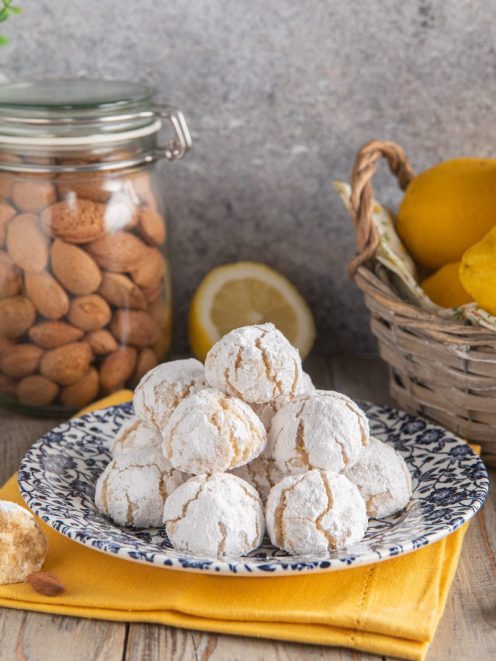 Biscotti al limone e mandorle ricoperti di zucchero a velo, con interno morbido in evidenza