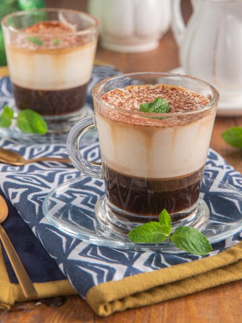 Caffè Padovano servito in tazza con strati di caffè, crema e cacao in polvere, guarnito con foglie di menta