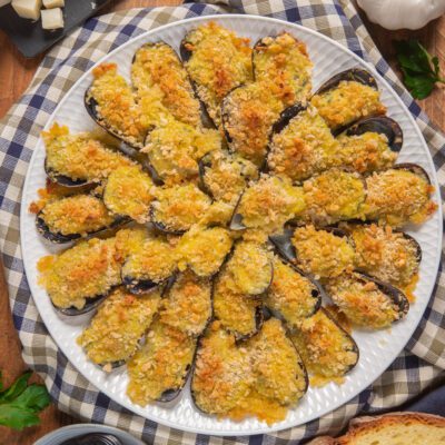 Cozze arraganate gratinate con pangrattato dorato e croccante, disposte a ventaglio