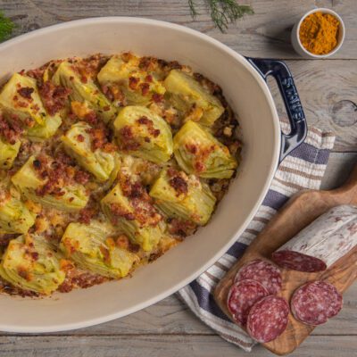 Finocchi gratinati allo zafferano con crosticina dorata e pezzi di cacciatorino in superficie