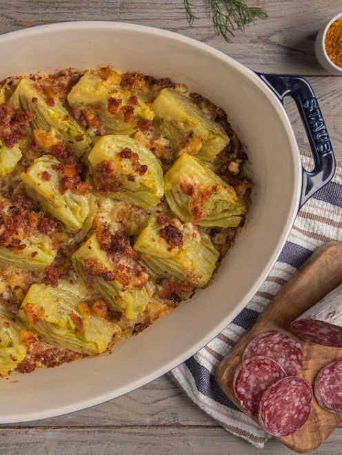 Finocchi gratinati allo zafferano con crosticina dorata e pezzi di cacciatorino in superficie
