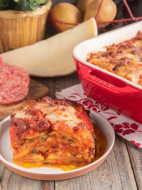 Parmigiana di patate e melanzane con cotechino a strati, con sugo di pomodoro e mozzarella filante
