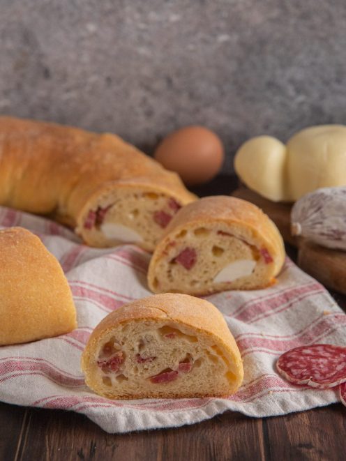 Pitta maniata tagliata a metà con provola e cacciatorino nell'impasto soffice e dorato