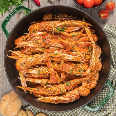 Scampi alla busara con salsa di pomodoro e prezzemolo fresco tritato