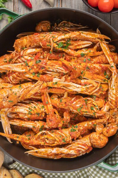 Scampi alla busara con salsa di pomodoro e prezzemolo fresco tritato