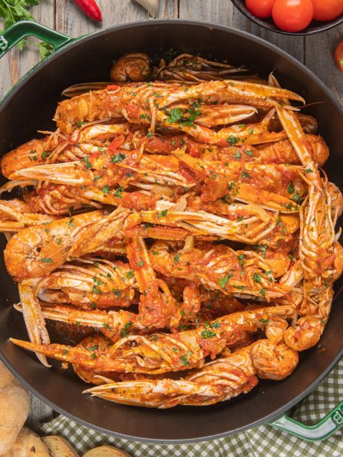 Scampi alla busara con salsa di pomodoro e prezzemolo fresco tritato