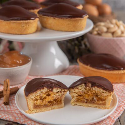 Fruttoni leccesi tagliati a metà che rivelano il ripieno di frutta secca e glassa al cioccolato