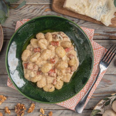 Gnocchi con sugo di noci, gorgonzola e mortadella in cremosa salsa ai formaggi con cubetti di salume