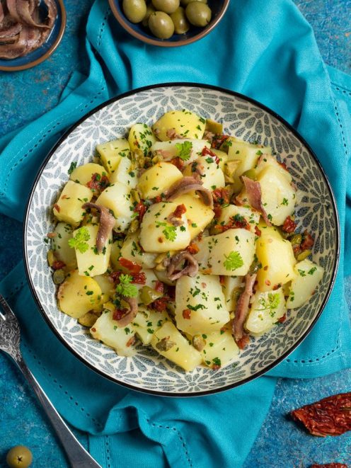 Insalata di patate con acciughe, olive, pomodori secchi, capperi e prezzemolo fresco