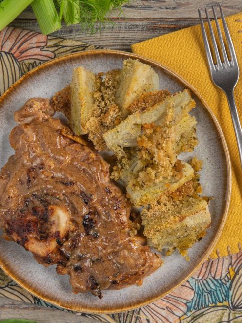Ossibuchi di vitello alla senape antica con salsa ricca, serviti accanto a finocchi al forno gratinati