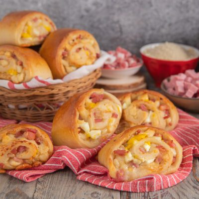 Panini napoletani dorati a spirale ripieni di salame, prosciutto cotto a cubetti e formaggio fuso