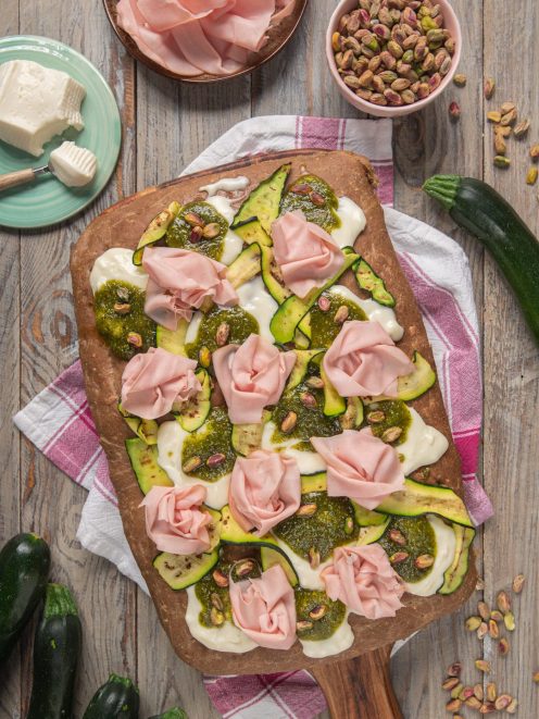 Focaccia ai cereali farcita con stracchino, zucchine grigliate, pesto di pistacchi e rose di mortadella