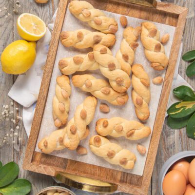 Intorchiate alle mandorle attorcigliate su vassoio con mandorle intere e limoni a fianco