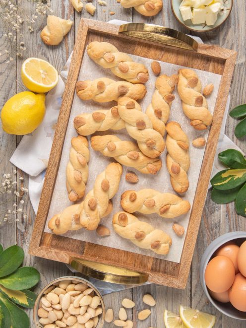 Intorchiate alle mandorle attorcigliate su vassoio con mandorle intere e limoni a fianco