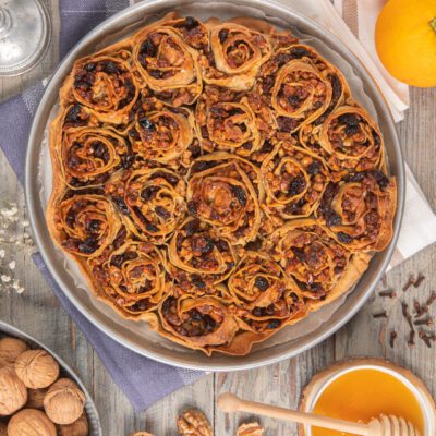 Pitta 'nchiusa con rotoli di pasta ripieni di noci, uvetta e miele dorato