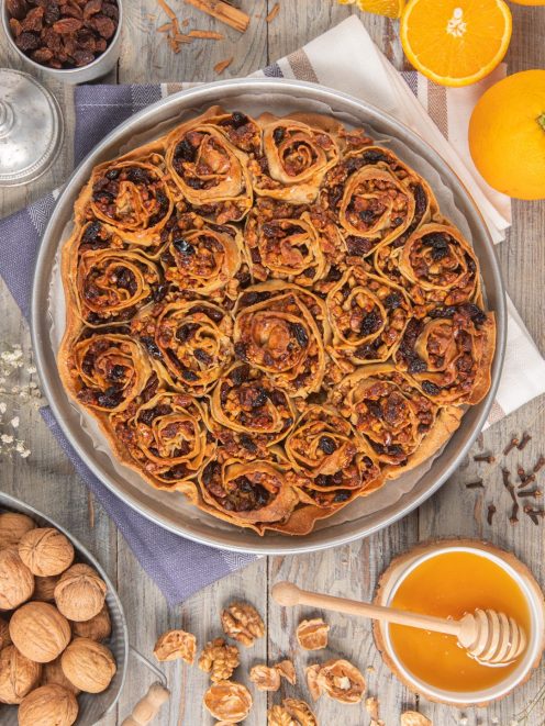 Pitta 'nchiusa con rotoli di pasta ripieni di noci, uvetta e miele dorato