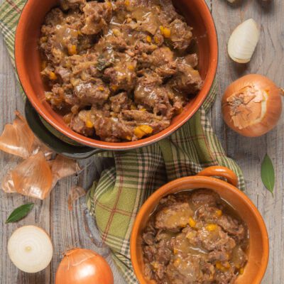 Ragù genovese con pezzi di carne e cipolla stufata in abbondante sugo dorato