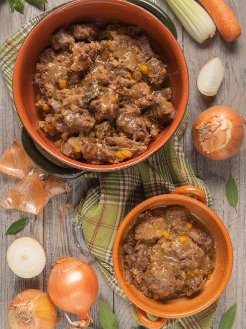 Ragù genovese con pezzi di carne e cipolla stufata in abbondante sugo dorato