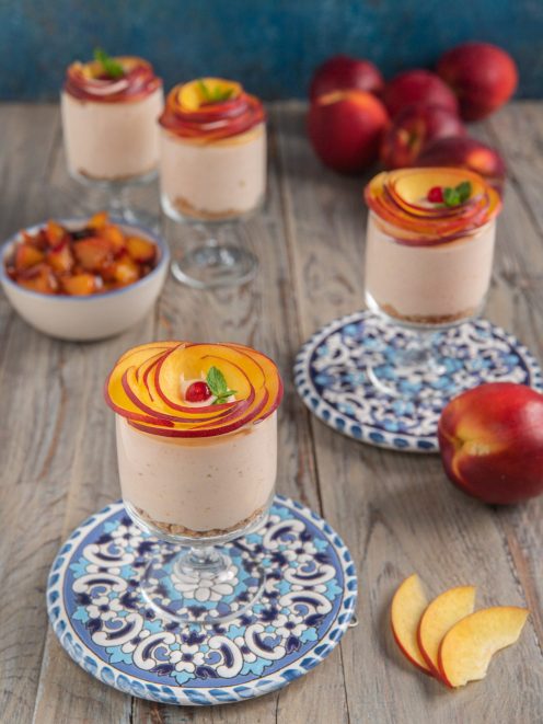 Cheesecake in bicchiere con base di biscotto, crema alla pesca e rose di nettarine fresche