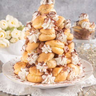 Bignolata mantovana a piramide con ciuffi di panna e scaglie di cioccolato fondente